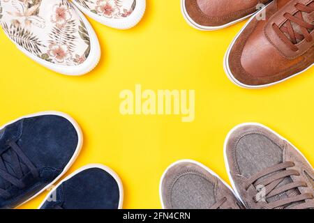 Four pairs of new stylish shoes on a yellow background. Flat lay. Copy space. Close up of shoes toes. Stock Photo