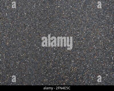 Dark pavement with grainy pockmarked texture. Full screen photo. Background texture Stock Photo