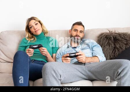 Man Playing Video Games At Home And His Girlfriend Bored Beside Looking At  Him Stock Photo, Picture and Royalty Free Image. Image 52407663.