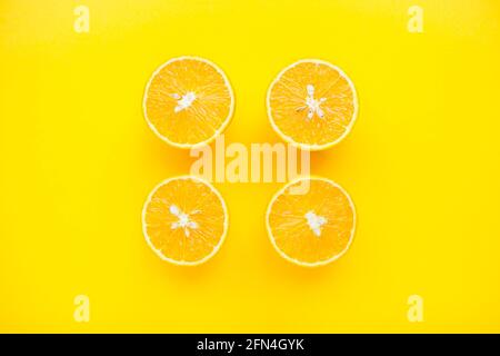 layout of bright orange oranges on a bright yellow background. Stock Photo