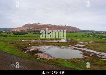 Loitsche Heinrichsberg, Germany. 13th May, 2021. On a field near the overburden of the Zielitz potash mine, depressions have filled with rainwater. According to the weather service, there may be showers and thunderstorms in Saxony-Anhalt this weekend. (Aerial photo with drone.) Credit: Stephan Schulz/dpa-Zentralbild/ZB/dpa/Alamy Live News Stock Photo