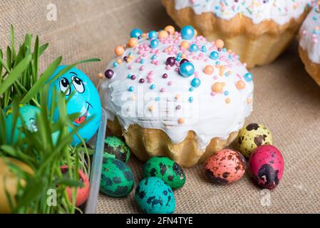 big Easter cake and colored eggs lie on the background Stock Photo