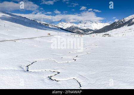 Aerial view of the snowy Pla de Beret in winter. Meanders of the Noguera Pallaresa river near its source (Aran Valley, Catalonia, Spain, Pyrenees) Stock Photo