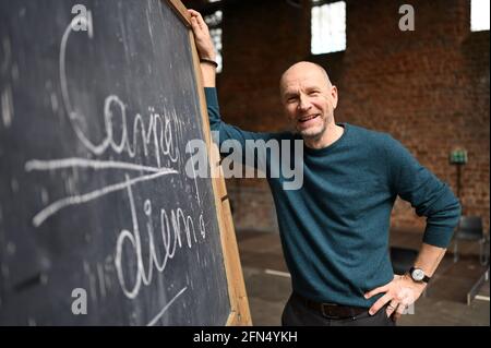 Bad Hersfeld, Germany. 14th May, 2021. Actor Götz Schubert (Keating in 'Dead Poets Society') stands in front of a plaque reading 'Carpe diem!' in the Bad Hersfeld Abbey Ruins. The Bad Hersfeld Festival is to open on July 1 with a stage version of the Hollywood film 'Dead Poets Society'. Credit: Uwe Zucchi/dpa/Alamy Live News Stock Photo