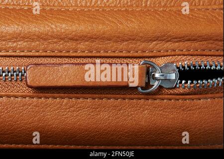 Brown leather puller on zip lock macro close up view Stock Photo