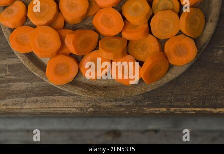 half of plate with cut carrots forming fresh vegetable texture top view with wood Stock Photo