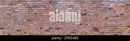 Colorful grunge brick wall made of old, mostly metallic colored bricks Stock Photo