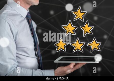 Quality concept above a tablet held by a man Stock Photo