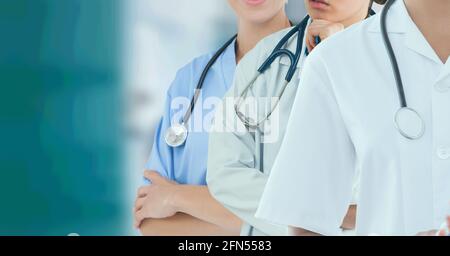 Mid section of team of medical professionals and health workers against hospital in background Stock Photo