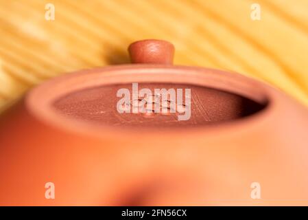 Holes in a Chinese teapot made of red Yixing clay, inside filter in the teapot spout Stock Photo