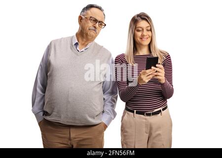 Angry father spying his daughter while typing on a smartphone isolated on white background Stock Photo