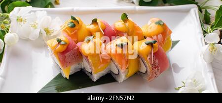 Sushi roll (Philadelphia) with salmon, smoked eel, avocado, cream cheese on black background. Sushi menu. Japanese food