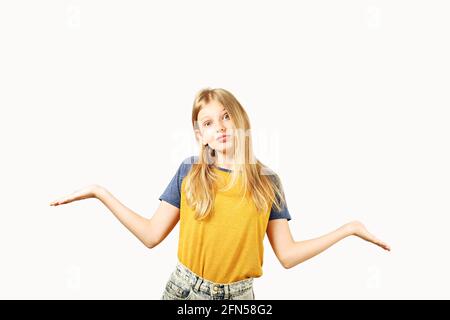 Young beautiful indecisive teenage girl with blond hair wearing yellow baseball t-shirt with blue sleeves, standing in shrugging pose. Pretty girl smi Stock Photo