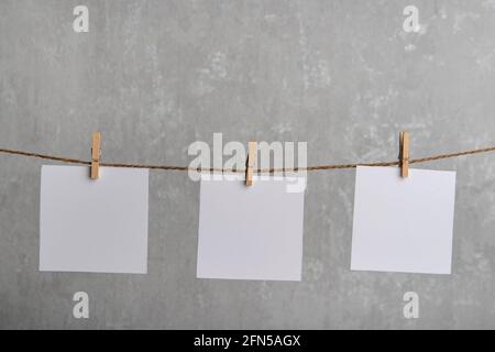 Blank white notes of paper hang with clothespins on rope. Place for your text. Copy space. Stock Photo