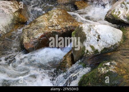 Details of the dramatic splash of water on a rock in a mountain river Stock Photo