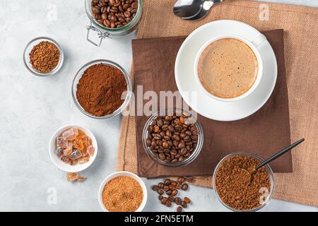 Different types of coffee and a cup of coffee on a gray background. Top view. Stock Photo