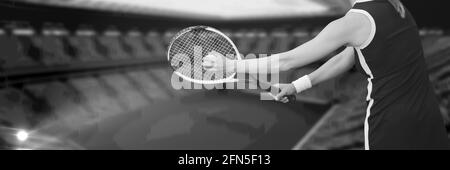 Composition of midsection of woman playing tennis over sports stadium in black and white Stock Photo