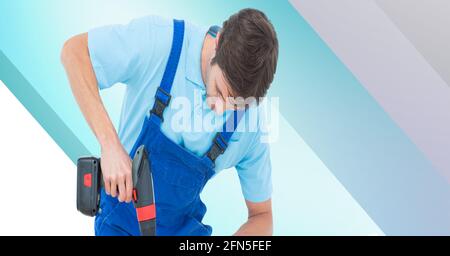 Caucasian handy man using drill on blue and white stripes Stock Photo