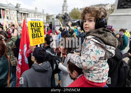 Child wearing ear muffs and sitting on parent's shoulders during 'Kill the Bill' protest against new policing bill, London, 1 May 2021 Stock Photo