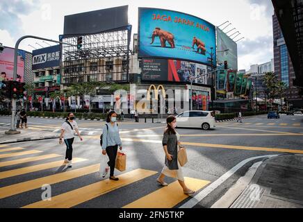 Kuala Lumpur, Malaysia. 14th May, 2021. Pedestrians wearing facemasks as a precaution against the spread of the coronavirus seen crossing the junction during the second day of the Hari Raya celebrations.Malaysia's Prime Minister Muhyiddin Yassin, has announced the whole of Malaysia is placed under the Movement Control Order (MCO) from May 12 to June 7, 2021, due to the rising of Covid-19 infections. Credit: SOPA Images Limited/Alamy Live News Stock Photo