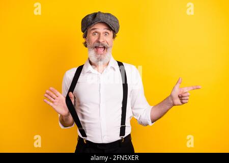 Photo portrait of bearded man in shirt suspenders staring pointing finger copyspace isolated vibrant yellow color background Stock Photo