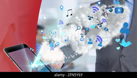 Multiple digital icons over smartphone against mid section of two businessmen shaking hands Stock Photo