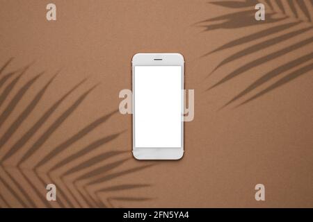 Modern smartphone on pastel colored background. Mock up for game design, mobile application, wallpapers, websites. Plant and shadows. Stock Photo