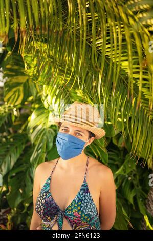 Young man with medical mask in tropical climate, new normal concept. Stock Photo