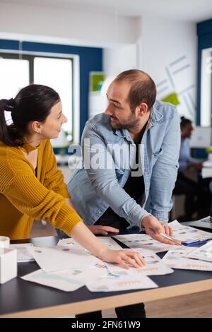 Financial advisor discussing with businesswoman of start up about statistics charts looking at each other. Diverse team of business people analyzing company financial reports from computer. Successful start up corporate professional entrepreneur online internet statistics Stock Photo