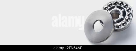 Stainless steel thrust ball bearing panoramic banner. Set of thrust ball bearing and shiny silver ball bearing. Spare parts for roller machine in heav Stock Photo
