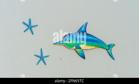 Isolated Dolphin and starfish art on gray wall Stock Photo