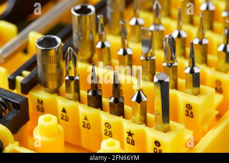 Set of heads for screwdriver. Tools collection.  close up, Bits in yellow holder Stock Photo