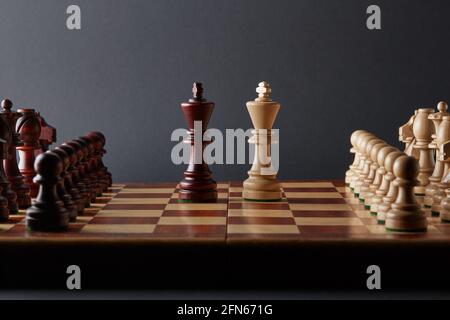 Classic Wooden Tournament chess set on black background. Two kings in centre of board other pieces lined up Stock Photo