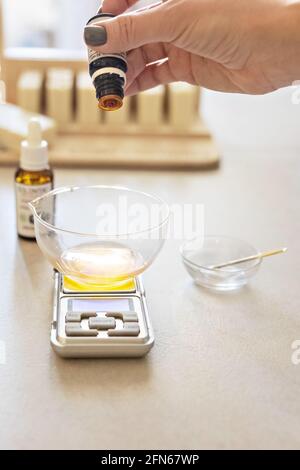 A soap-maker weighs aromatic oils for making cosmetics on a kitchen scale.  Home spa. Small business Stock Photo - Alamy