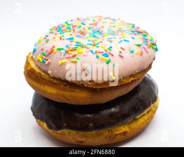 Chocolate doughnut over a doughnut with powdered sugar colored on background.  Stock Photo