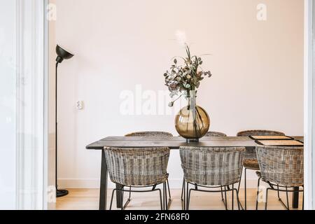 Vase with flowers on table in dining room Stock Photo