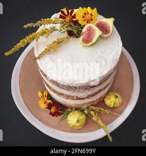 Vanilla Layer Cake Decorated with Edible Fresh Flowers and Fruit Stock Photo