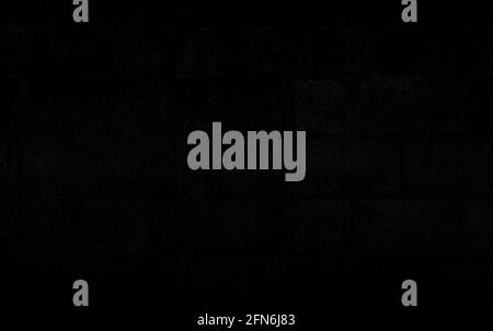 Dark gray, almost black, old and aged wall made of stone blocks. Dark high resolution full frame textured background. Stock Photo