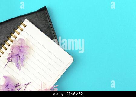 Business diary concept, notebook with purple flowers on bright background, flat lay and copy space Stock Photo