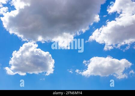 White fluffy clouds float across the blue sky. Beautiful natural background. Stock Photo