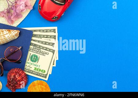 Journey planning and summer trip concept flat lay composition, money red car toy and seashells on blue background, top view and copy space template Stock Photo