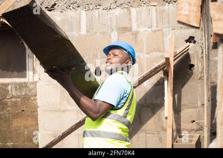 a carpenter carrying wood on site Stock Photo