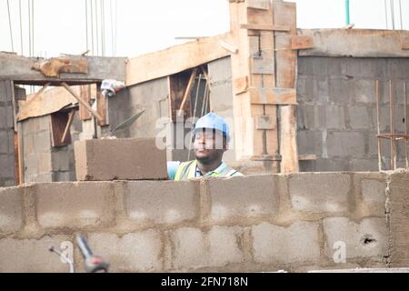 an african bricklayer laying bricks Stock Photo