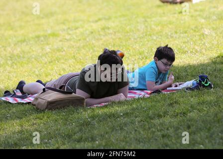 New York, USA. 14th May, 2021. People enjoy themselves in Central Park in New York, the United States, May 14, 2021. The U.S. Centers for Disease Control and Prevention (CDC) will no longer recommend masks for fully-vaccinated Americans indoors or outdoors, including in crowds, according to its new guidance announced on Thursday. Credit: Wang Ying/Xinhua/Alamy Live News Stock Photo