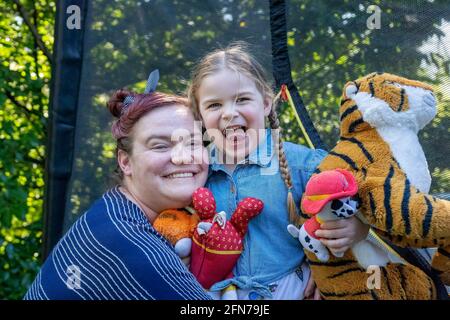 Lynwood, Washington, USA.  Four year old girl and her mother hugging and being affectionate.  (MR) Stock Photo