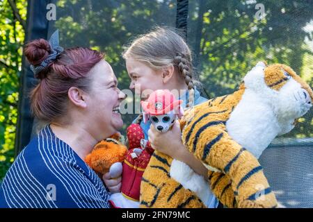 Lynwood, Washington, USA.  Four year old girl and her mother hugging and being affectionate.  (MR) Stock Photo