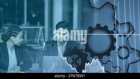 Composition of digital diagrams and icons over businesspeople using laptop Stock Photo