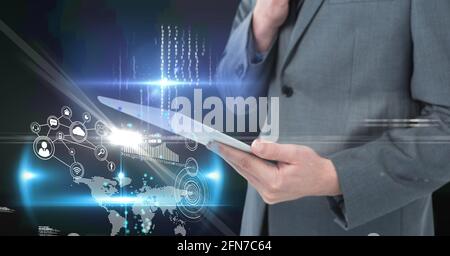 Composition of digital icons over caucasian businessman with tablet Stock Photo