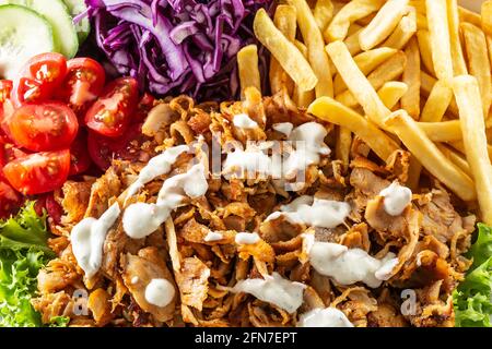 Top view closeup of Turkish grilled kebab with homegrown vegetables, salty fries and tasty dressing. Stock Photo