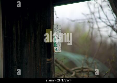 an old clock hangs on the wall of the building, in the spring Stock Photo
